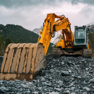 Bagr nabírající kamennou suť