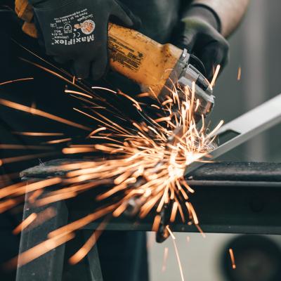 Dělník s frézou řezající železnou tyč